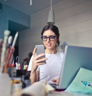 woman in white shirt using smartphone